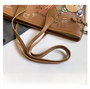 Detailed close-up of brown tote bag showing colorful cartoon graffiti print and stitching