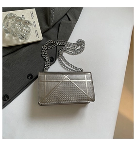 Dettagli della borsa a catena argento con motivi geometrici e borchie metalliche