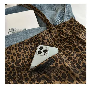 Detail shot of leopard print canvas tote bag featuring a practical front storage pocket