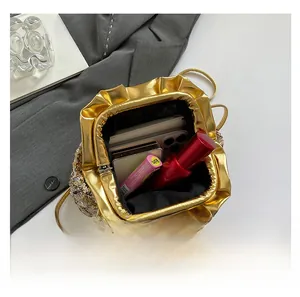 Detail showing the internal storage capacity of the sequined gold clutch bag with items