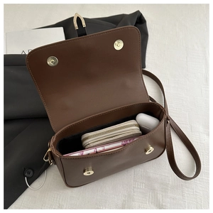 Detail of dark brown leather crossbody bag interior showing spacious storage capacity