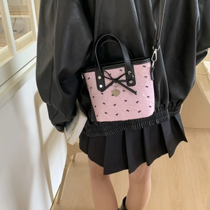 Sac seau rose chic avec motifs de nœuds noirs et pendentif cœur, style bandoulière
