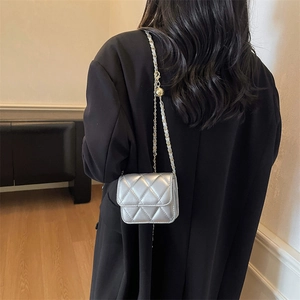 Chic silver quilted mini cross-body bag with metallic finish and chain strap on model