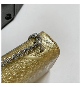 Dettaglio borsa trapuntata dorata con catena metallica classica e fibbie in metallo argento