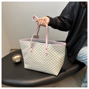 Macro detail of large tote bag with beige monogram pattern and pink leather trim details
