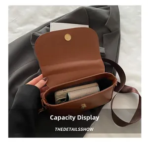 Macro shot showing internal capacity of the brown faux suede saddle bag with phone and wallet