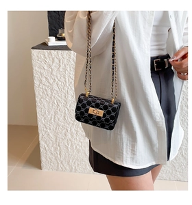 Detail of the gray jacquard chain bag featuring a floral texture and golden twist lock
