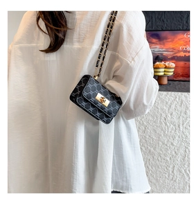 Detail of vintage monogram flap bag with gold twist lock and chain strap on shoulder