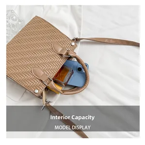 Interior capacity of woven shoulder bag showing space for phone and perfume bottle