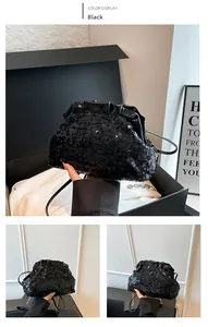 Detail of black sequin cloud bag with glossy patent leather pleats and slim strap
