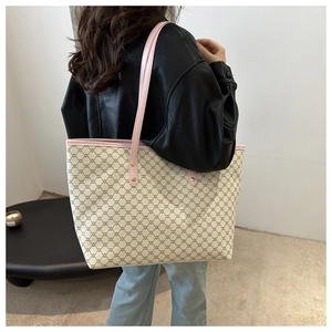 Detailed shoulder view of a large tote bag with vintage monogram and pink leather straps
