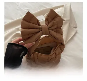Spacious interior of brown quilted bow handbag showing storage for phone and makeup