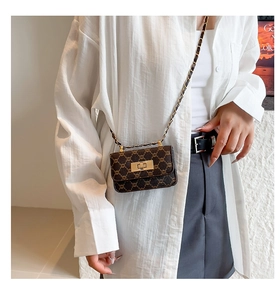 Close-up of vintage plaid patterns with metallic clasp and gold chain strap detail