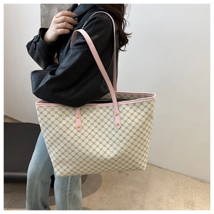 Side view of large tote bag with pink trim and geometric pattern on a fashion model