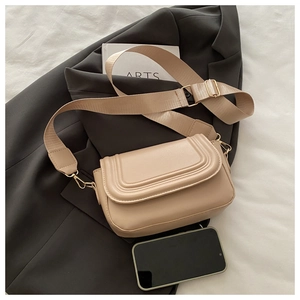 Dettaglio ravvicinato della borsa a tracolla trapuntata beige con ampia tracolla in tessuto