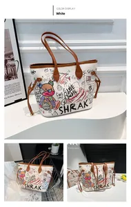 Close-up of a white tote bag featuring colorful graffiti prints and brown leather handles