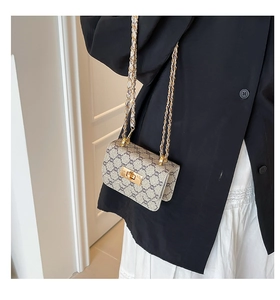 Detail of vintage monogram crossbody bag with gold metallic lock and chain strap