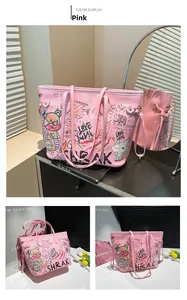 Close-up of pink faux leather tote bag featuring street art graffiti and side lace detail