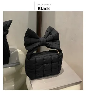 Dettaglio borsa trapuntata nera con manico a fiocco oversize e cerniera dorata elegante