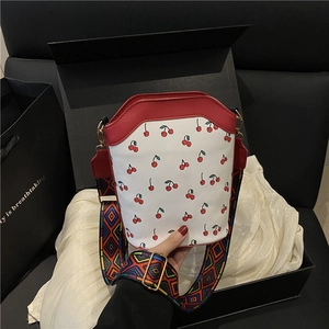 Stylish white leather bucket bag with red cherry print and colorful geometric wide strap