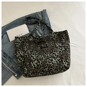 Close-up of retro green leopard print canvas tote bag with functional front pocket detail