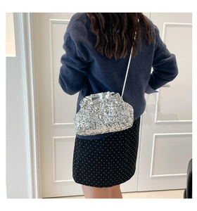 Silver sequin cloud bag detail showing metallic texture and delicate chain strap on model