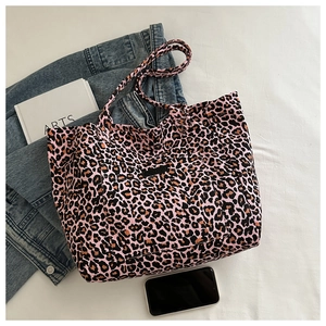Close-up of leopard print canvas tote bag with front pocket and dual shoulder straps