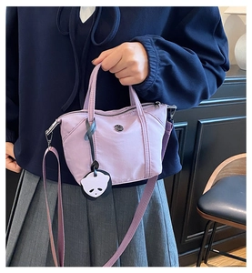 Detailed view of lavender mini tote bag with panda pendant and adjustable strap