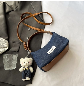 Detail of denim patchwork crossbody bag with brown leather trim and cute bear charm