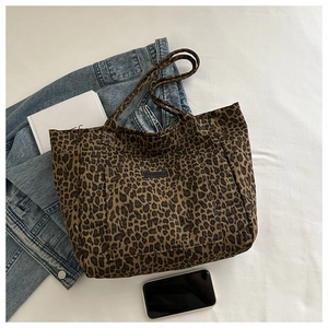 Macro view of leopard print canvas tote bag with textured fabric and vintage brand patch