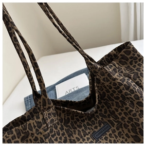 Detail of leopard print canvas tote bag featuring black leather FASHION & BAGS patch