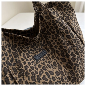Close-up of leopard print canvas bag showing thick fabric texture and logo patch