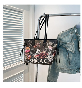 Detail of a large black tote bag featuring street art graffiti and bear illustrations