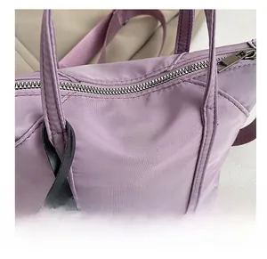 Macro shot of purple nylon fabric texture and M FASHION metal logo on small handbag