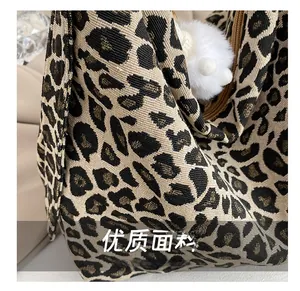 Detailed view of leopard jacquard fabric texture and soft white faux fur ball charm