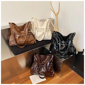 Detail of four retro tote bags in polished leather showing buckle straps and large capacity