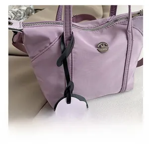 Detailed macro view of lavender mini tote bag featuring silver hardware and bear charm
