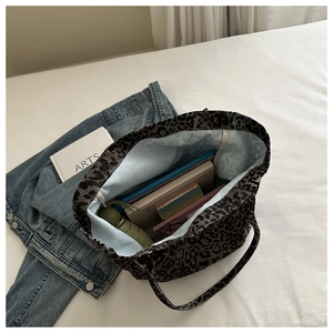 Top view of spacious leopard print tote bag interior holding books and accessories