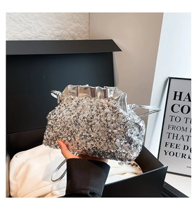 Detailed view of silver sequin shoulder bag with pleated closure and metallic trim