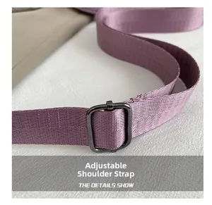 Detail showing the adjustable purple nylon shoulder strap with dark metal buckle for a handbag