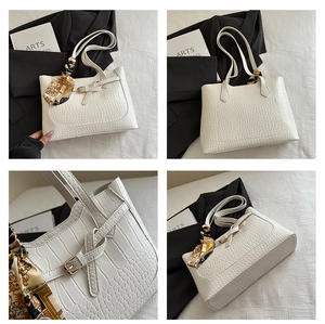 Close-up of white crocodile pattern tote bag with decorative scarf handle and PU leather texture