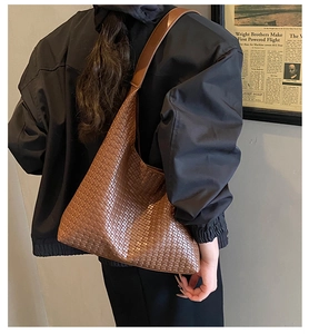 Borsa hobo intrecciata marrone scuro portata a spalla per outfit autunnali