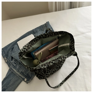 Top view of large leopard print canvas tote bag showing spacious interior with books and tablet
