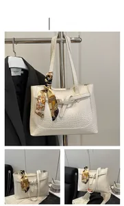 Detailed view of white tote bag with crocodile pattern and decorative silk scarf
