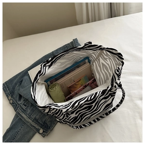 Detailed top view of large capacity zebra print tote bag interior filled with books