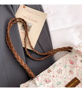 Detail of woven leather handles and cute bunny print on a stylish ruched tote bag