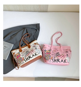 Detail view of vintage graffiti tote bags with cat and bear prints on a soft bed