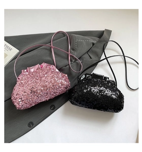 Detailed view of pink and black sequin cloud bags on a grey suit jacket background