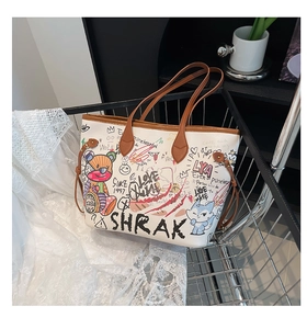 Detail of white graffiti tote bag featuring colorful illustrations in a metal basket