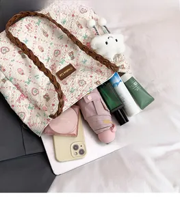 Spacious interior of floral quilted tote bag holding umbrella, phone, and cosmetics